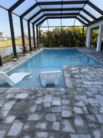 Pool with in-water chairs and screened enclosure