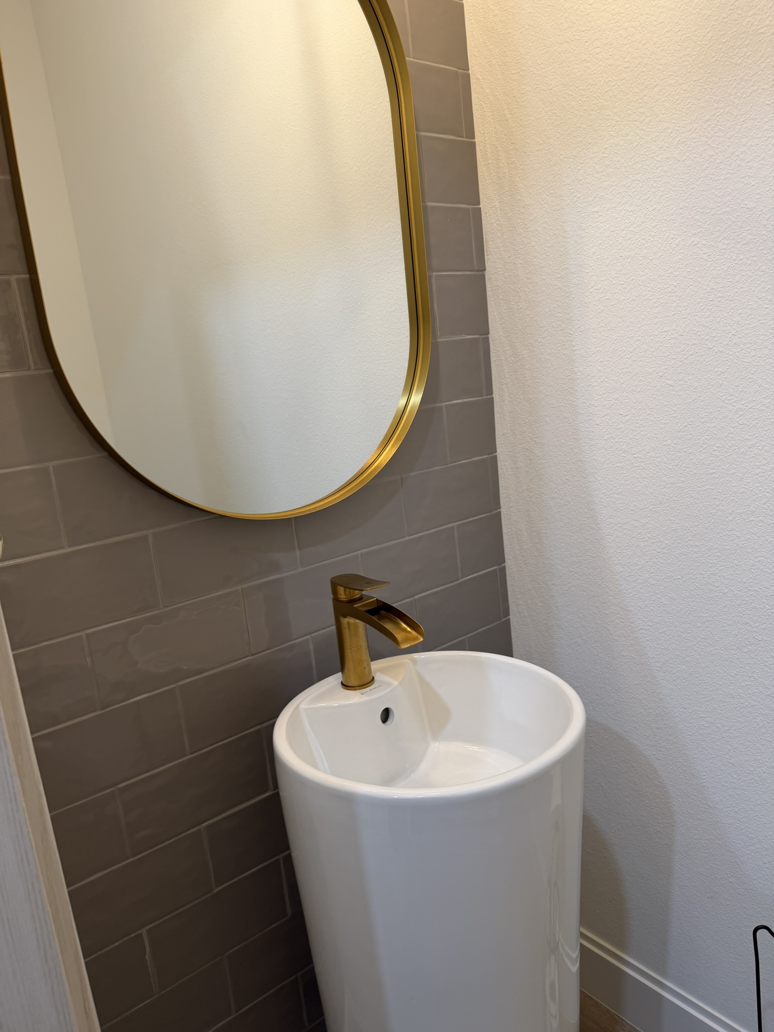 Half bath with pedestal sink and gold faucet
