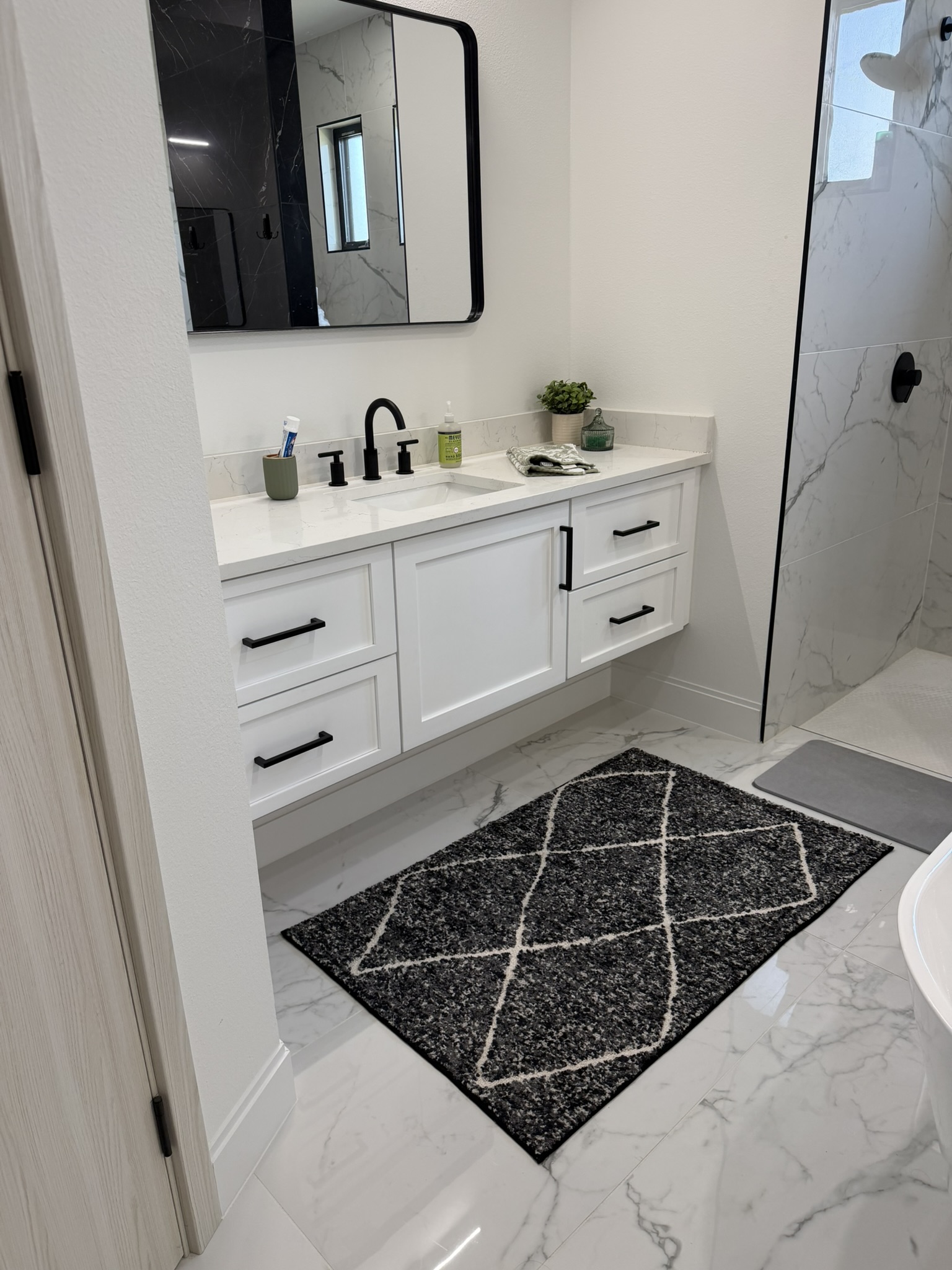 Primary bathroom with marble tile and floating vanity
