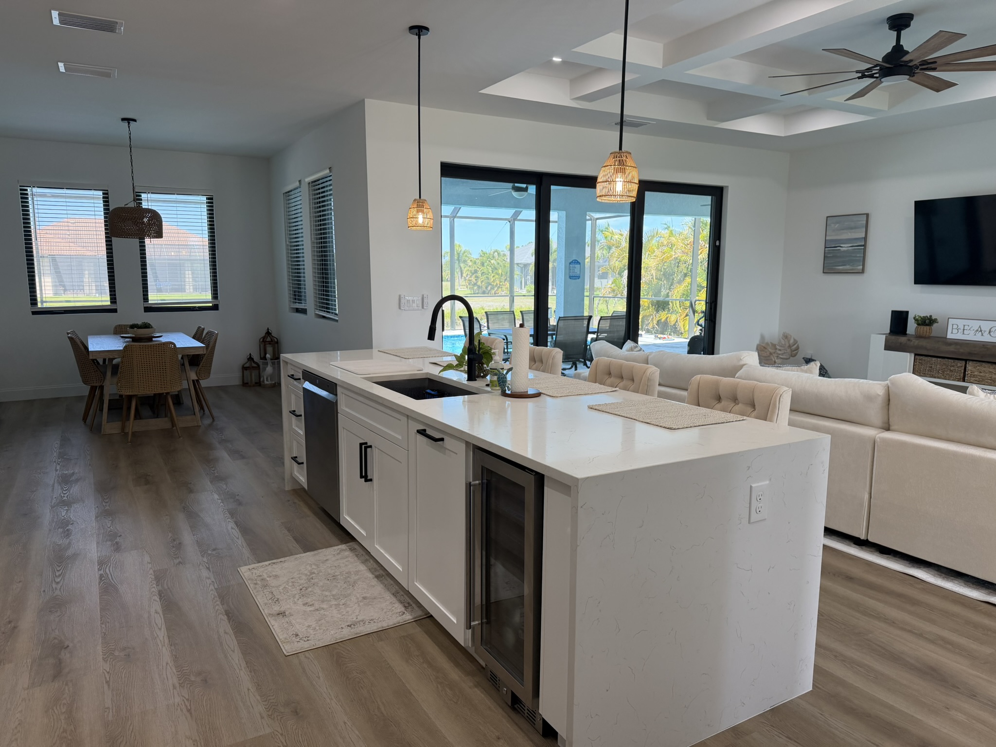 Open-plan kitchen, dining, and living area with coffered ceiling