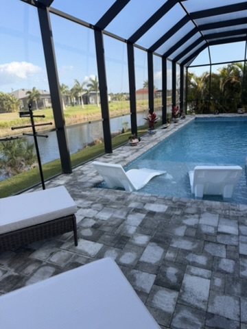 Pool with in-water lounge chairs and canal views
