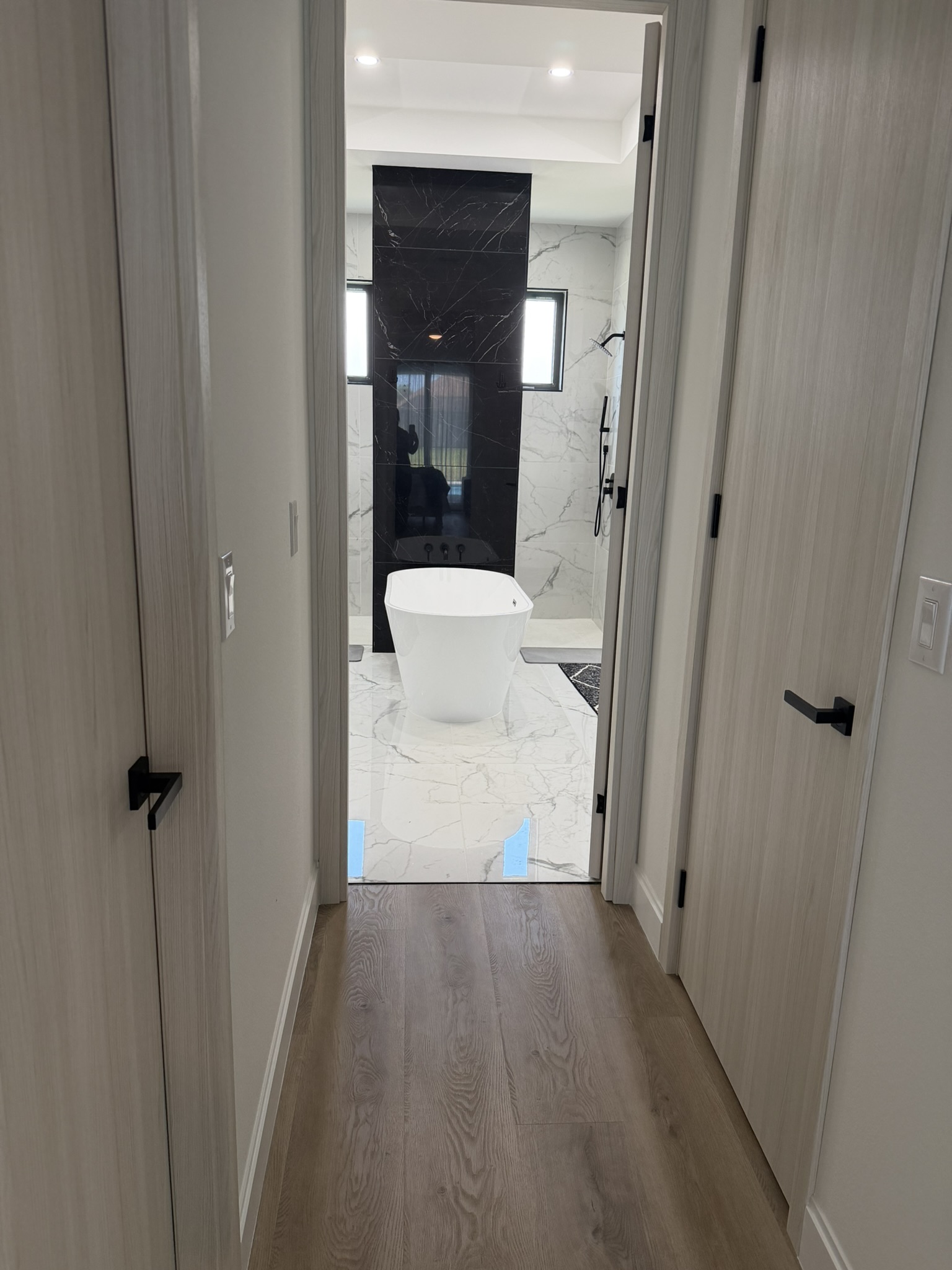 Hallway framing view into master bath with soaking tub