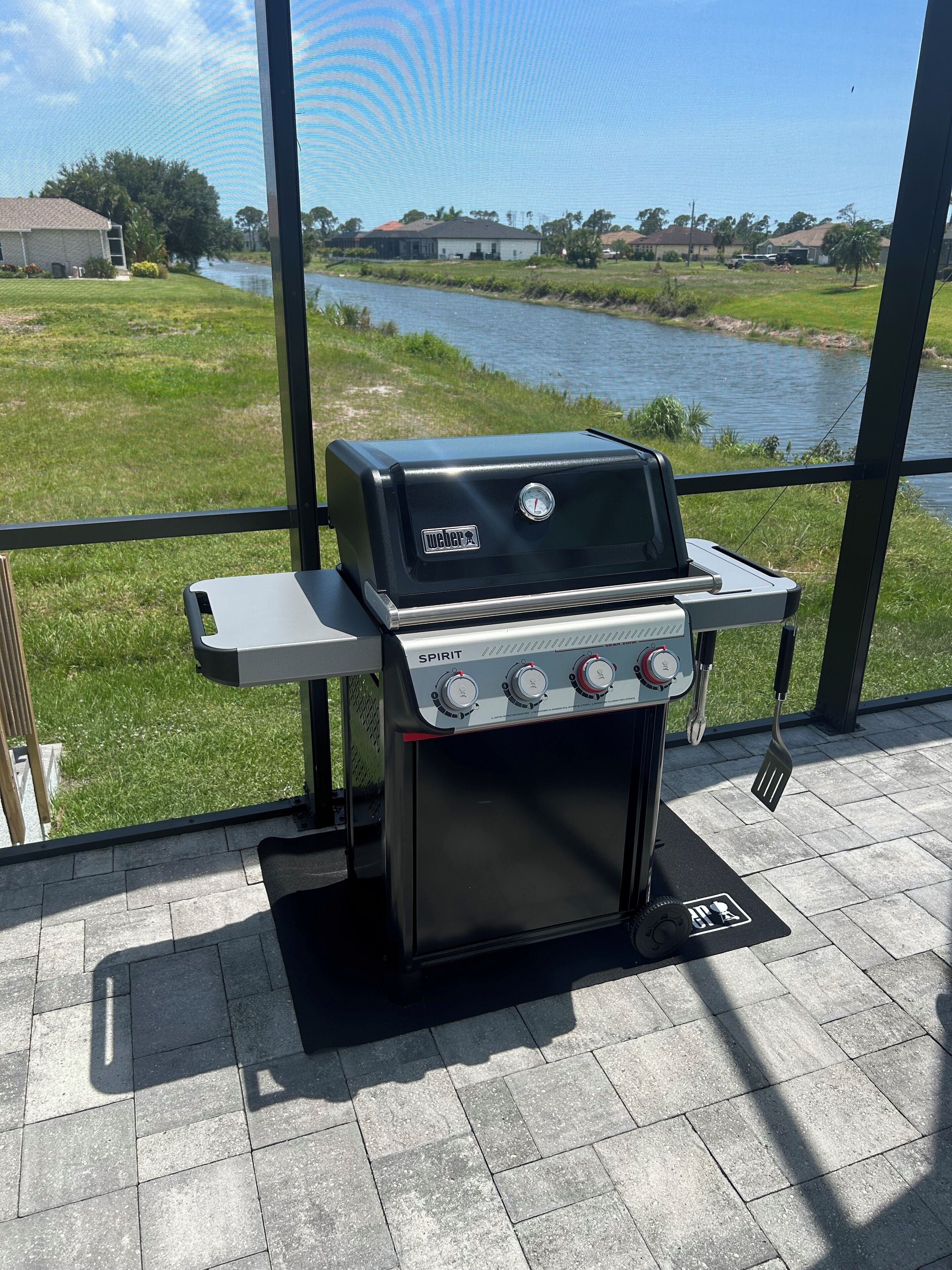 Weber grill on screened patio with canal view