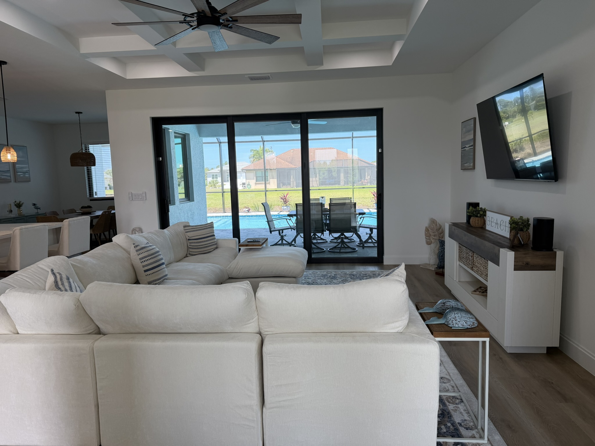 Living room with coffered ceiling and pool view