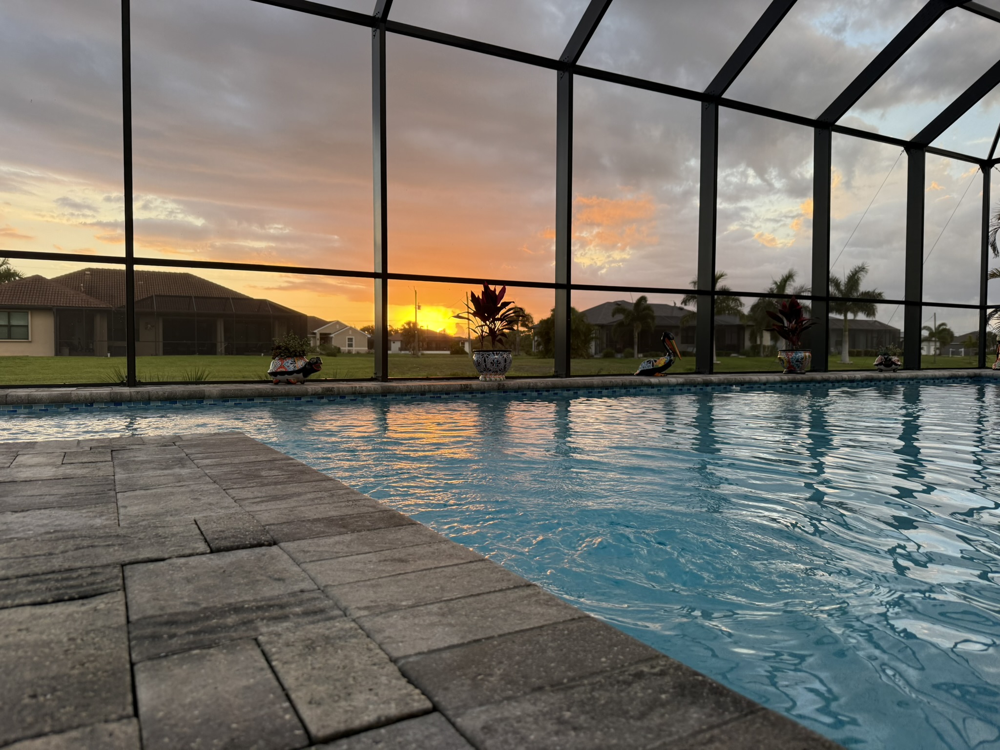 Private screened pool at sunset with canal views